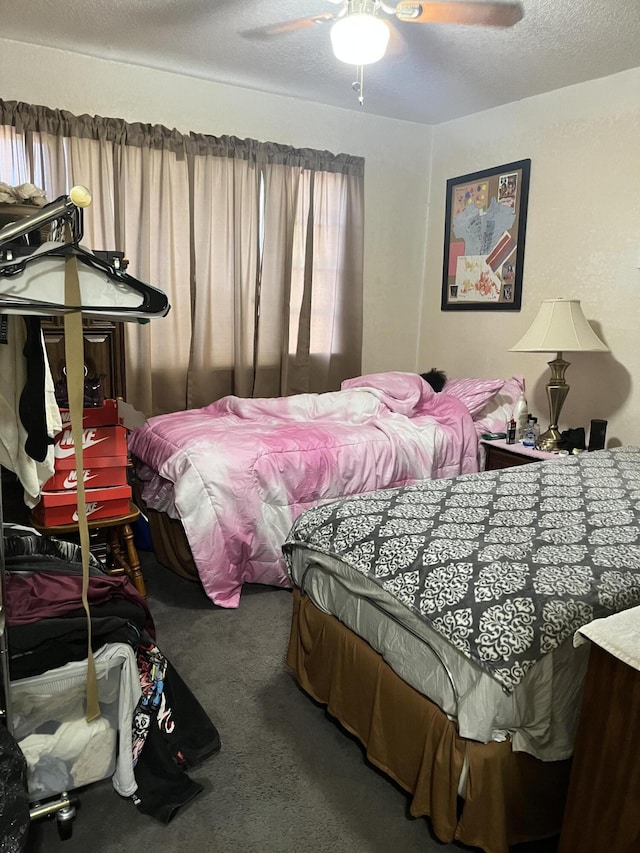 carpeted bedroom featuring a textured ceiling and ceiling fan