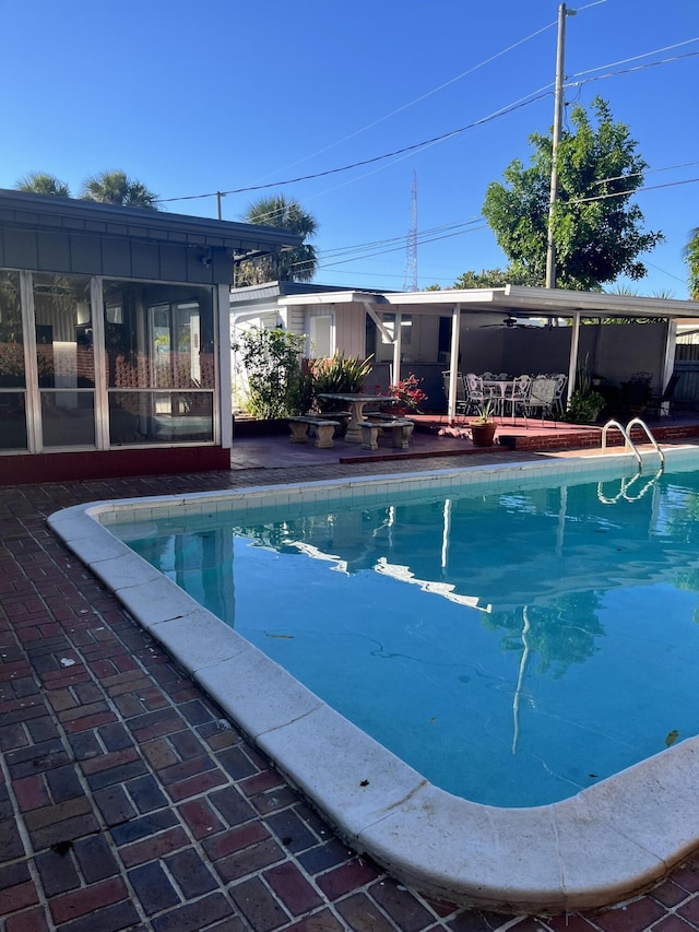 view of swimming pool featuring a sunroom