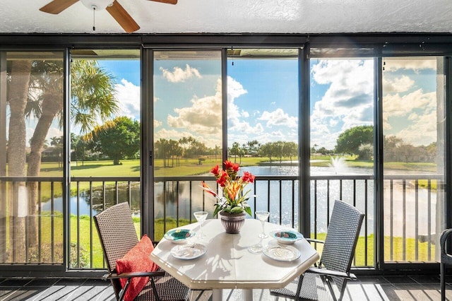 sunroom featuring ceiling fan, a wealth of natural light, and a water view