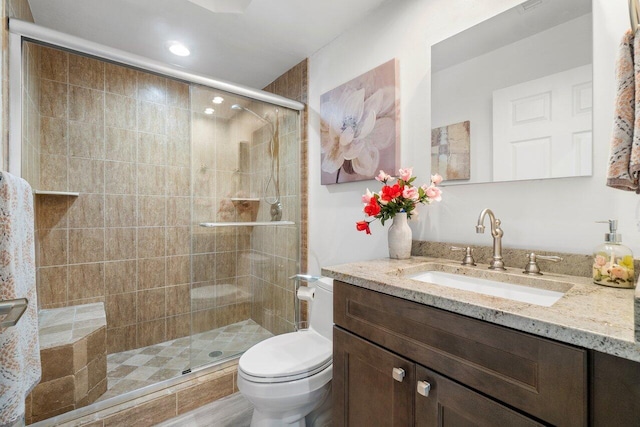 bathroom with toilet, vanity, and an enclosed shower