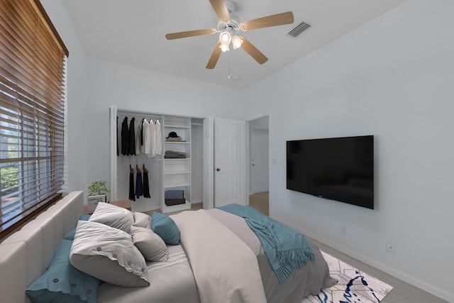 bedroom with a closet, ceiling fan, and light colored carpet