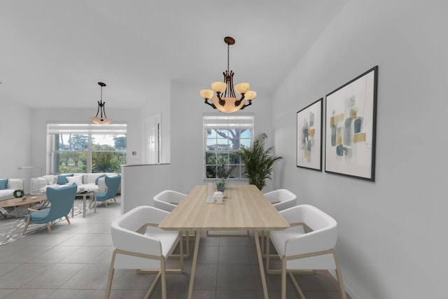 dining space featuring tile patterned floors and an inviting chandelier