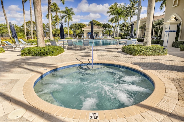 view of swimming pool featuring a community hot tub and a patio