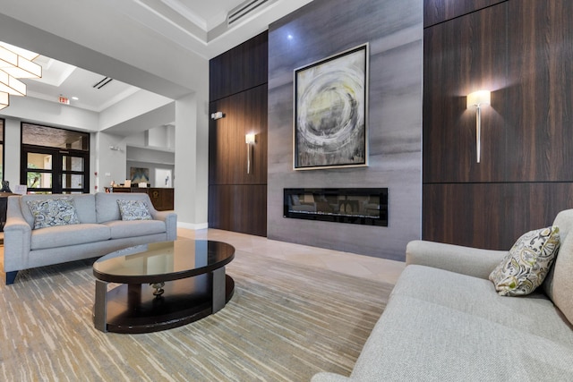 living room with crown molding, a towering ceiling, and a fireplace