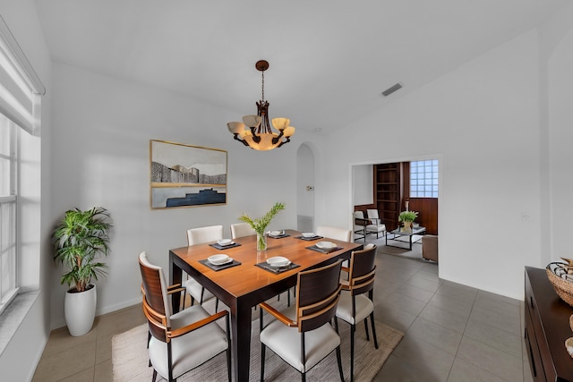 dining space featuring tile patterned floors, a wealth of natural light, and lofted ceiling