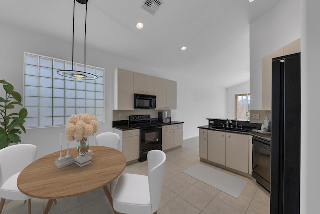 kitchen with sink, vaulted ceiling, decorative light fixtures, light tile patterned flooring, and black appliances