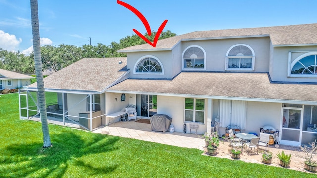 rear view of property featuring a yard and a patio