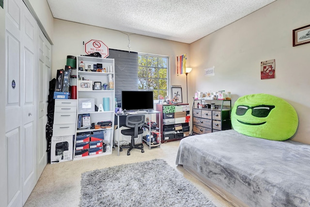 carpeted bedroom featuring a textured ceiling and a closet