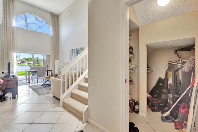 tiled foyer with a textured ceiling, high vaulted ceiling, and a wealth of natural light