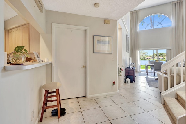 tiled foyer with a healthy amount of sunlight and a textured ceiling