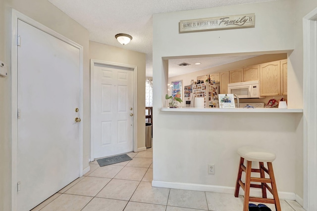 tiled foyer featuring a textured ceiling