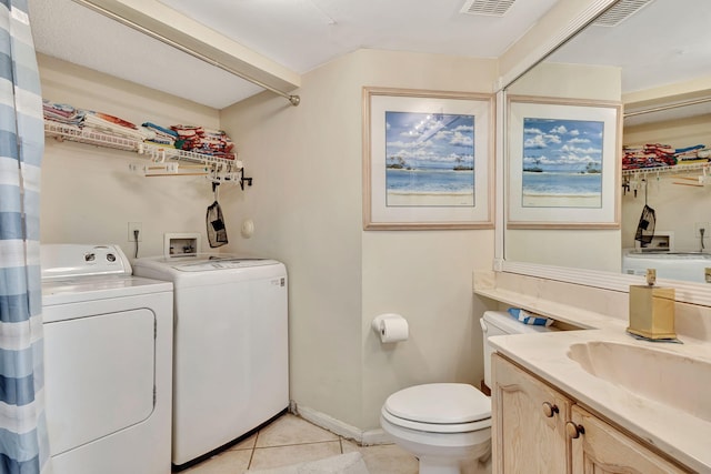 bathroom with washer and clothes dryer, vanity, toilet, and tile patterned floors