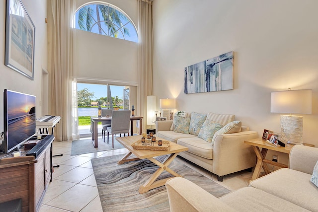 tiled living room with a high ceiling and plenty of natural light