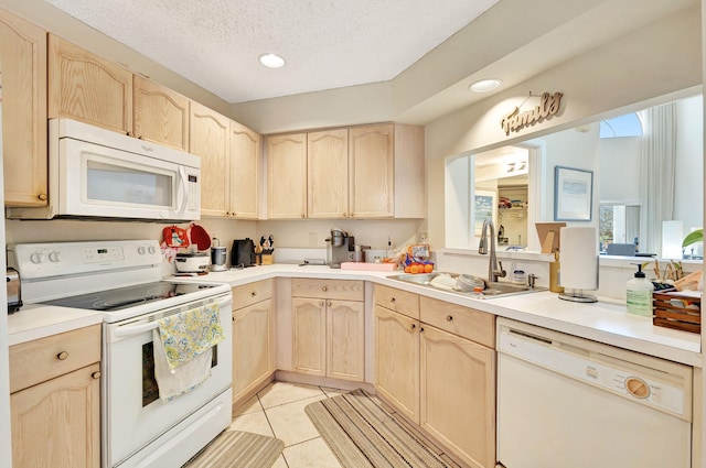 kitchen featuring light brown cabinetry, sink, and white appliances