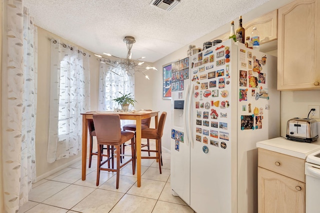 tiled dining room with a textured ceiling and a notable chandelier