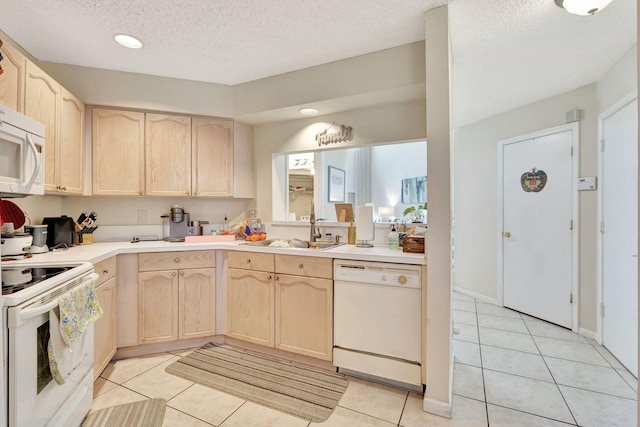 kitchen with light brown cabinetry, white appliances, a textured ceiling, sink, and light tile patterned floors