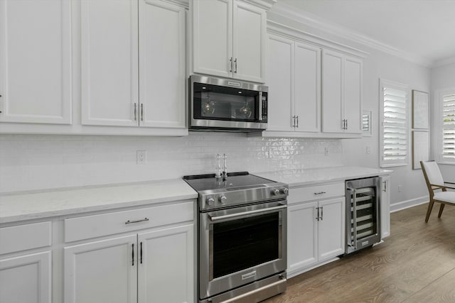 kitchen with white cabinets, appliances with stainless steel finishes, and wine cooler