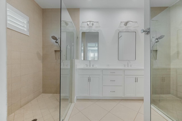 bathroom with vanity, tiled shower, and tile patterned floors