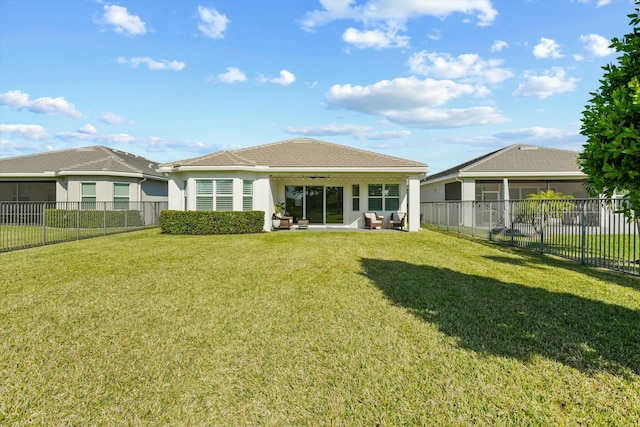 rear view of house featuring a patio and a lawn