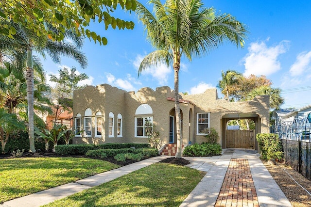 mediterranean / spanish home with a front lawn and a carport