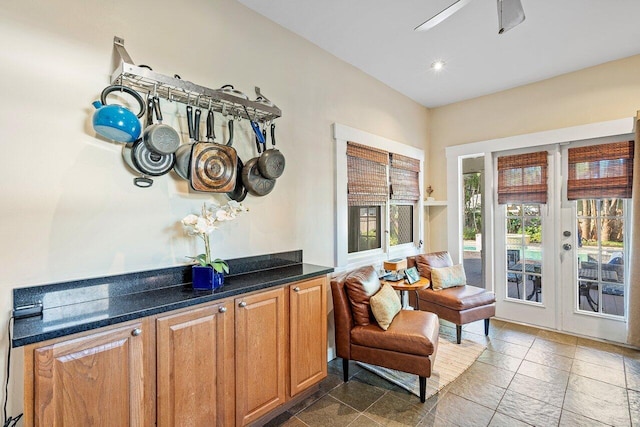 living area with tile patterned floors and ceiling fan