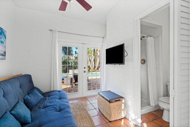 tiled living room with ceiling fan and french doors