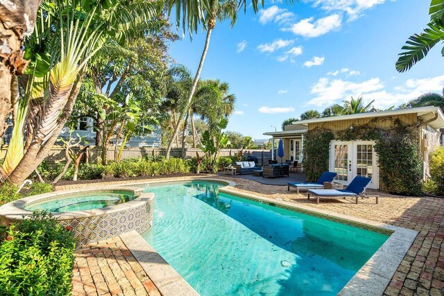 view of pool with an in ground hot tub, french doors, a patio, and an outdoor hangout area