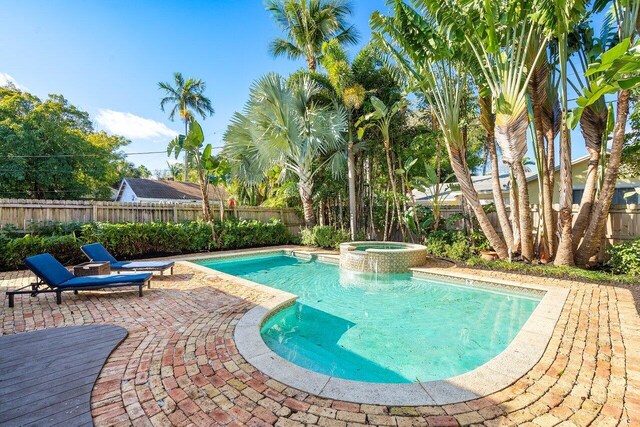 view of swimming pool featuring an in ground hot tub and a patio