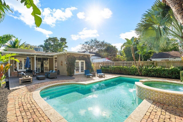 view of swimming pool featuring an outdoor living space, french doors, pool water feature, an in ground hot tub, and a patio