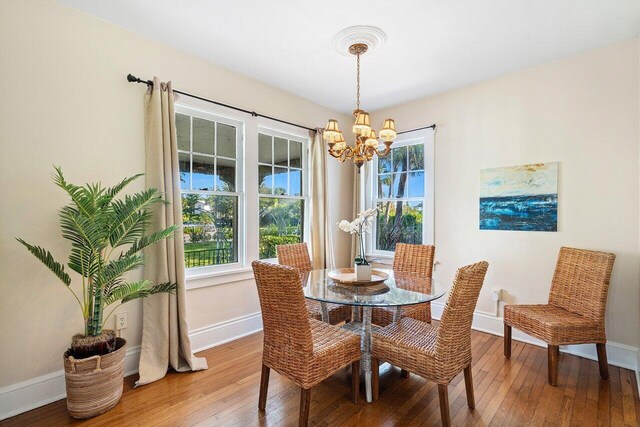 dining area with an inviting chandelier and hardwood / wood-style flooring