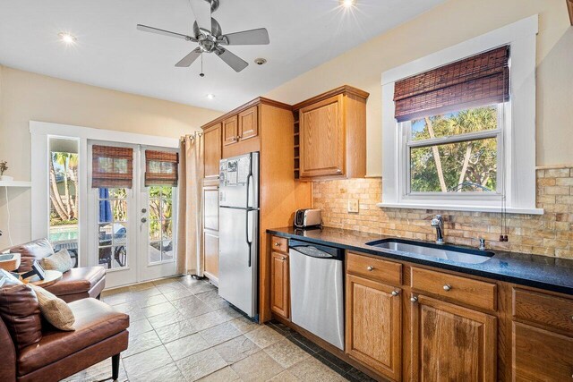 kitchen featuring decorative backsplash, appliances with stainless steel finishes, ceiling fan, and sink