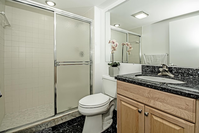 bathroom with toilet, an enclosed shower, and vanity