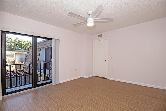 spare room with ceiling fan, a textured ceiling, and wood-type flooring