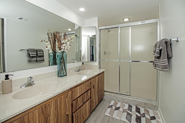 bathroom featuring a shower with door, vanity, and wood-type flooring