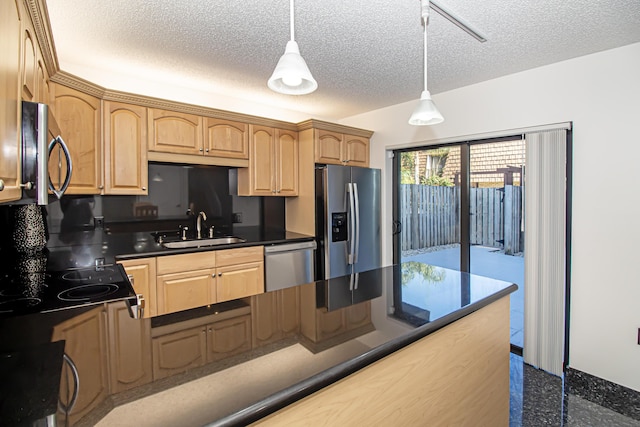 kitchen featuring appliances with stainless steel finishes, pendant lighting, a textured ceiling, and sink