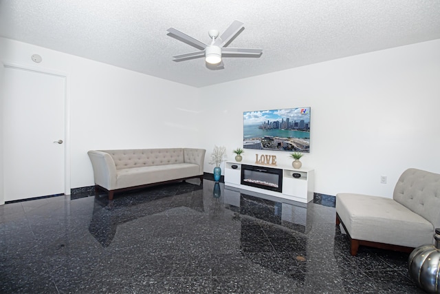 living room featuring a textured ceiling and ceiling fan