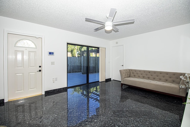 foyer entrance featuring ceiling fan and a textured ceiling