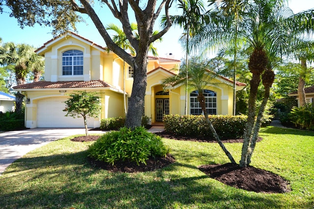 mediterranean / spanish house with a front yard and a garage