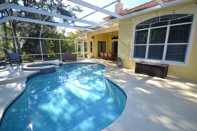 view of pool with an in ground hot tub, a patio, and glass enclosure