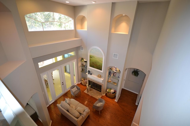 living room featuring french doors, a towering ceiling, and dark hardwood / wood-style floors