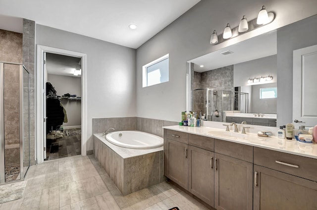 bathroom with vanity, a healthy amount of sunlight, and separate shower and tub