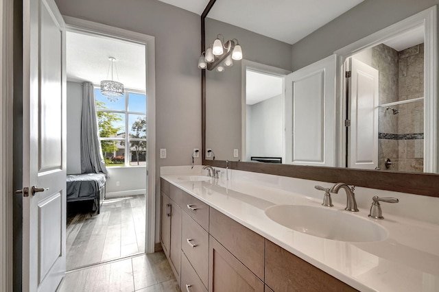 bathroom featuring wood-type flooring, a tile shower, and vanity