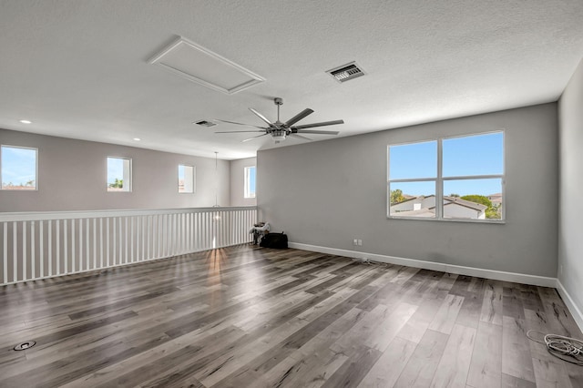 unfurnished room with hardwood / wood-style flooring, a textured ceiling, and a healthy amount of sunlight