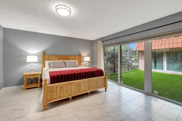 bedroom featuring access to exterior and a textured ceiling