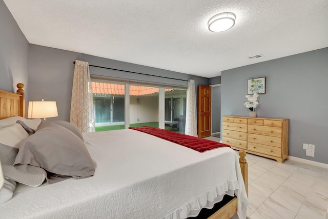 bedroom with access to outside and a textured ceiling