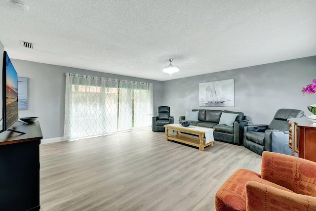 living room featuring light hardwood / wood-style flooring and a textured ceiling