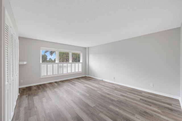 empty room featuring wood-type flooring and a textured ceiling