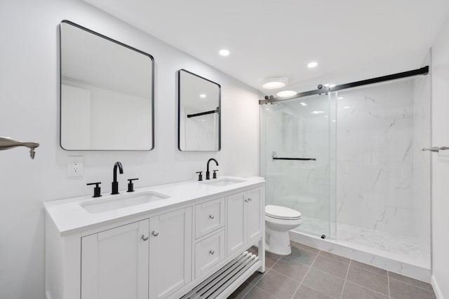 bathroom with vanity, toilet, and a shower with door