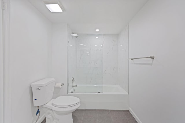 bathroom featuring tiled shower / bath, tile patterned floors, and toilet