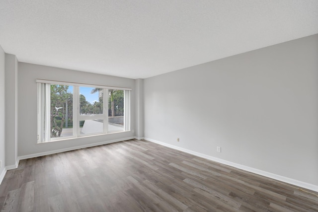 empty room featuring hardwood / wood-style flooring and a textured ceiling